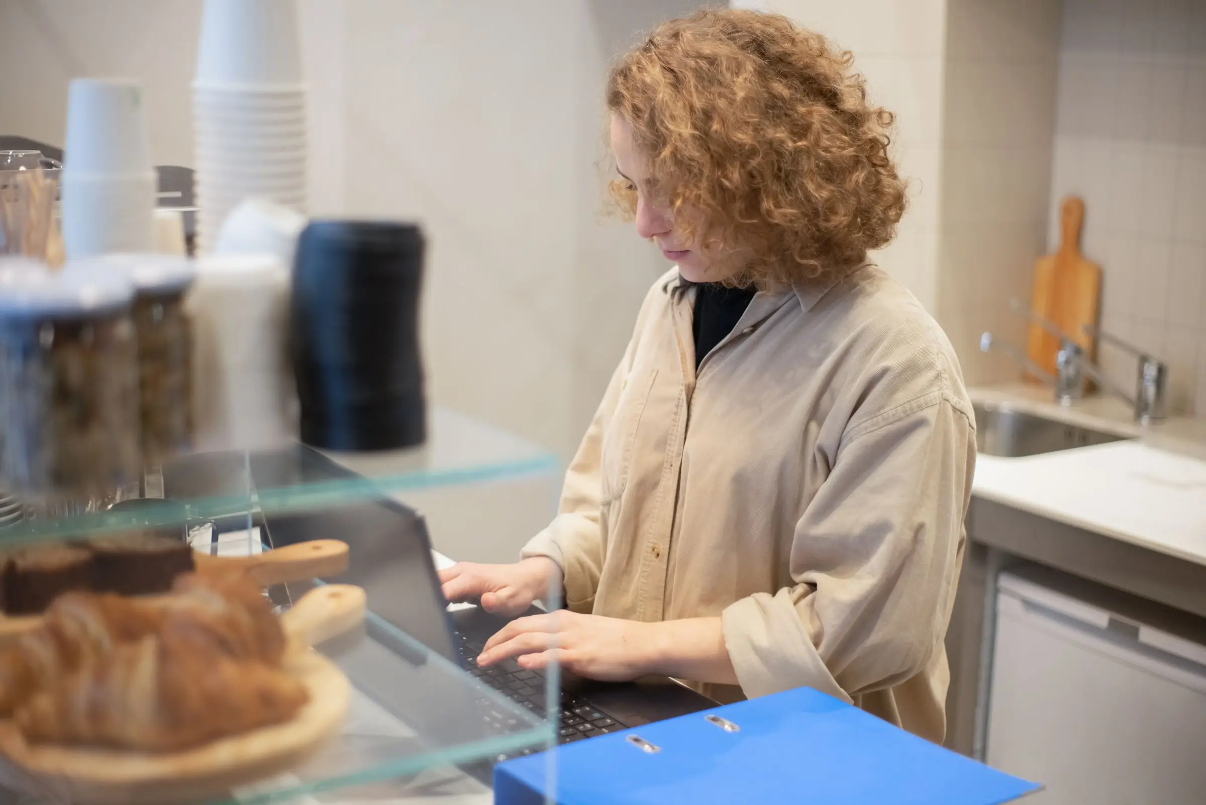 Shop owner working at the computer behind her café counter